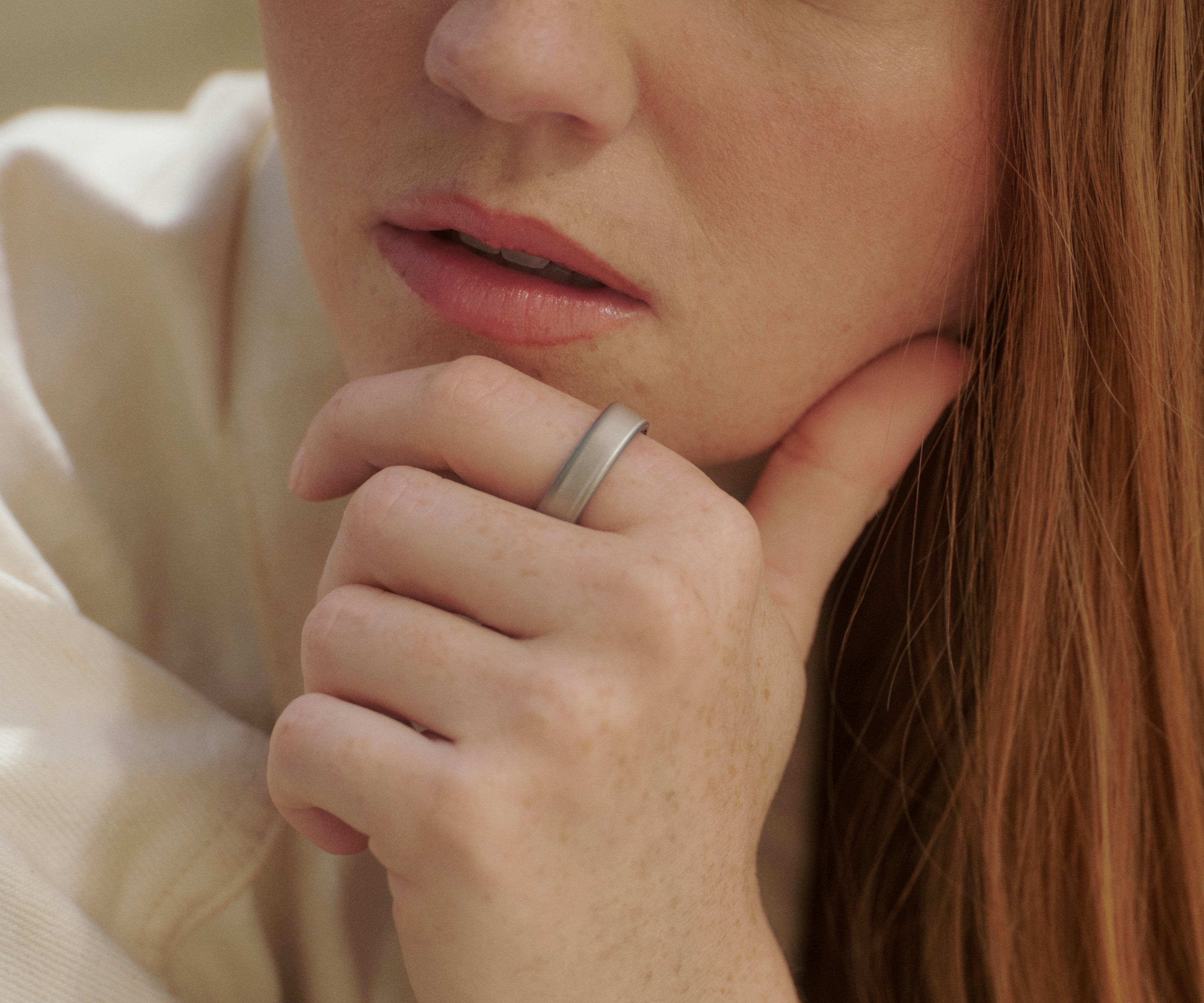 特写镜头：一人佩戴 Brushed Silver Oura Ring 5，神态沉静，若有所思。