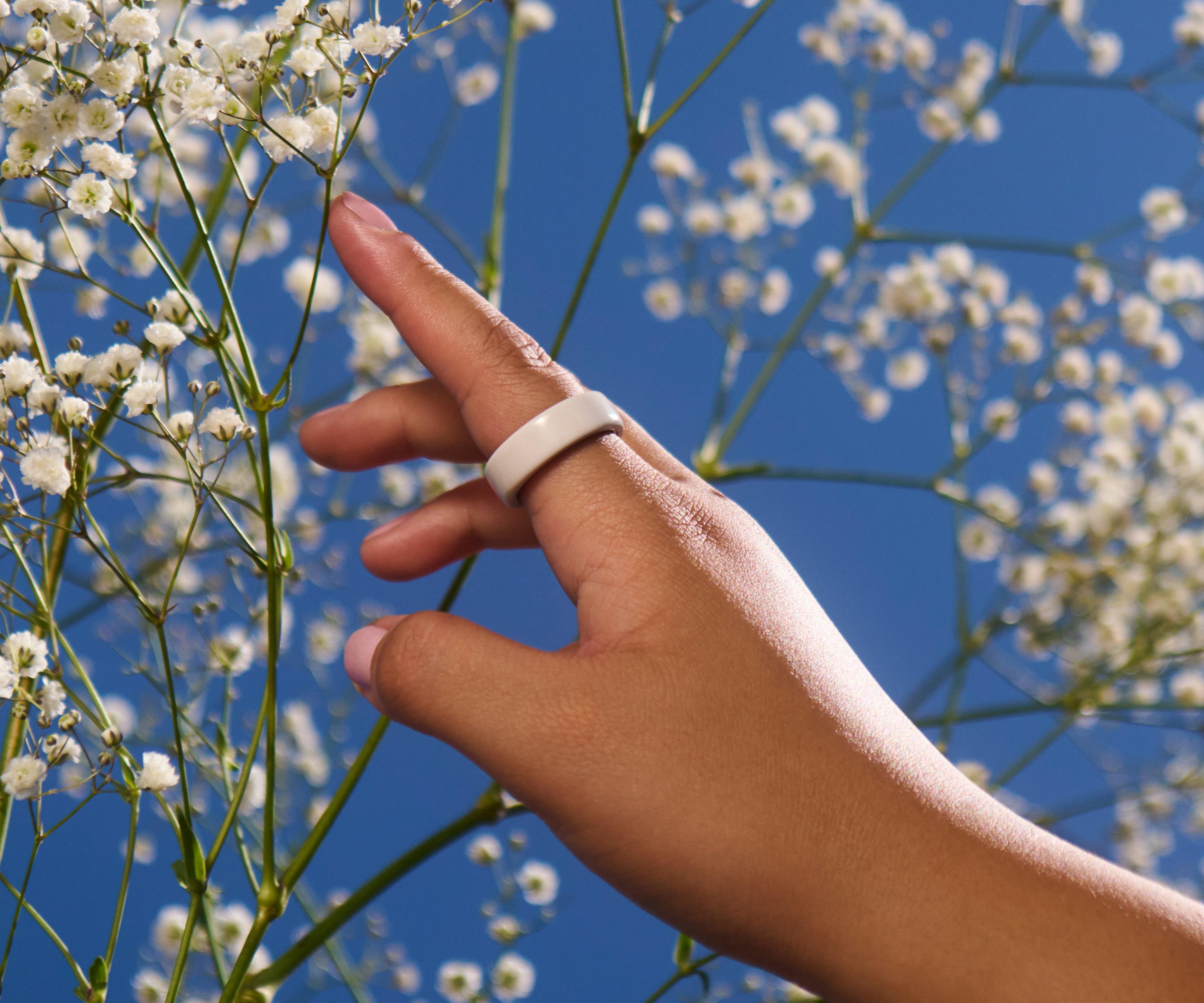 一个佩戴 Cloud Oura Ring 4 Ceramic 的人的手部特写