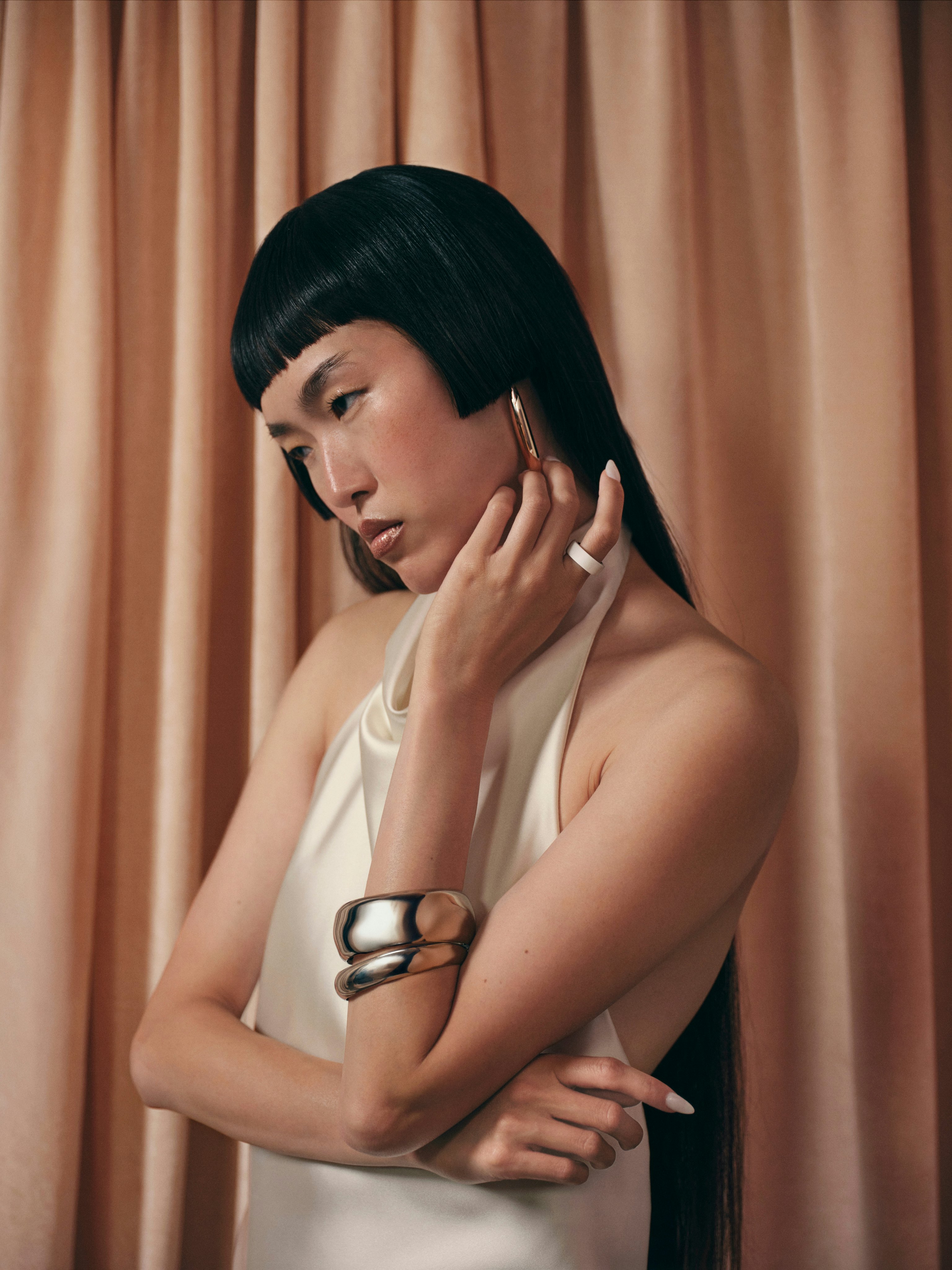 一個人戴著 Cloud 色 Oura Ring 4 Ceramic