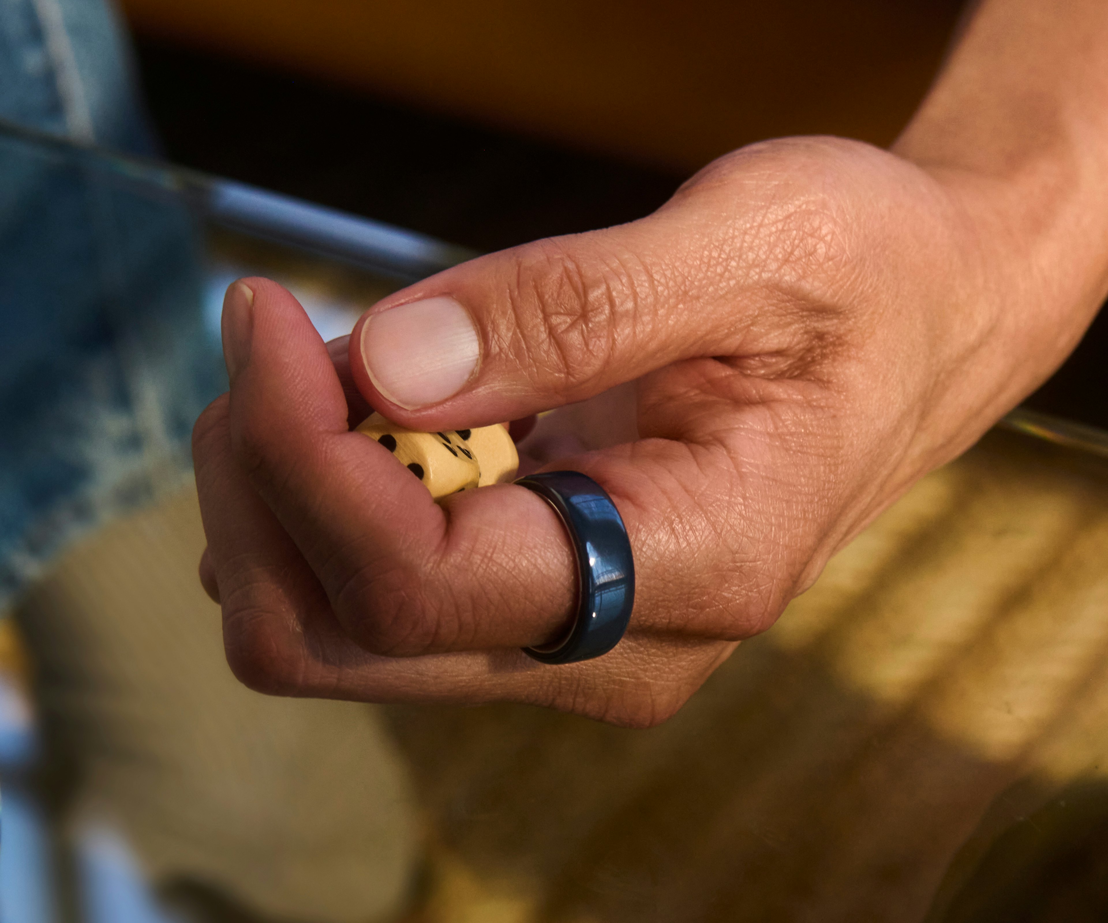 一個人手指上戴著 Midnight 色 Oura Ring 4 Ceramic 的手部特寫