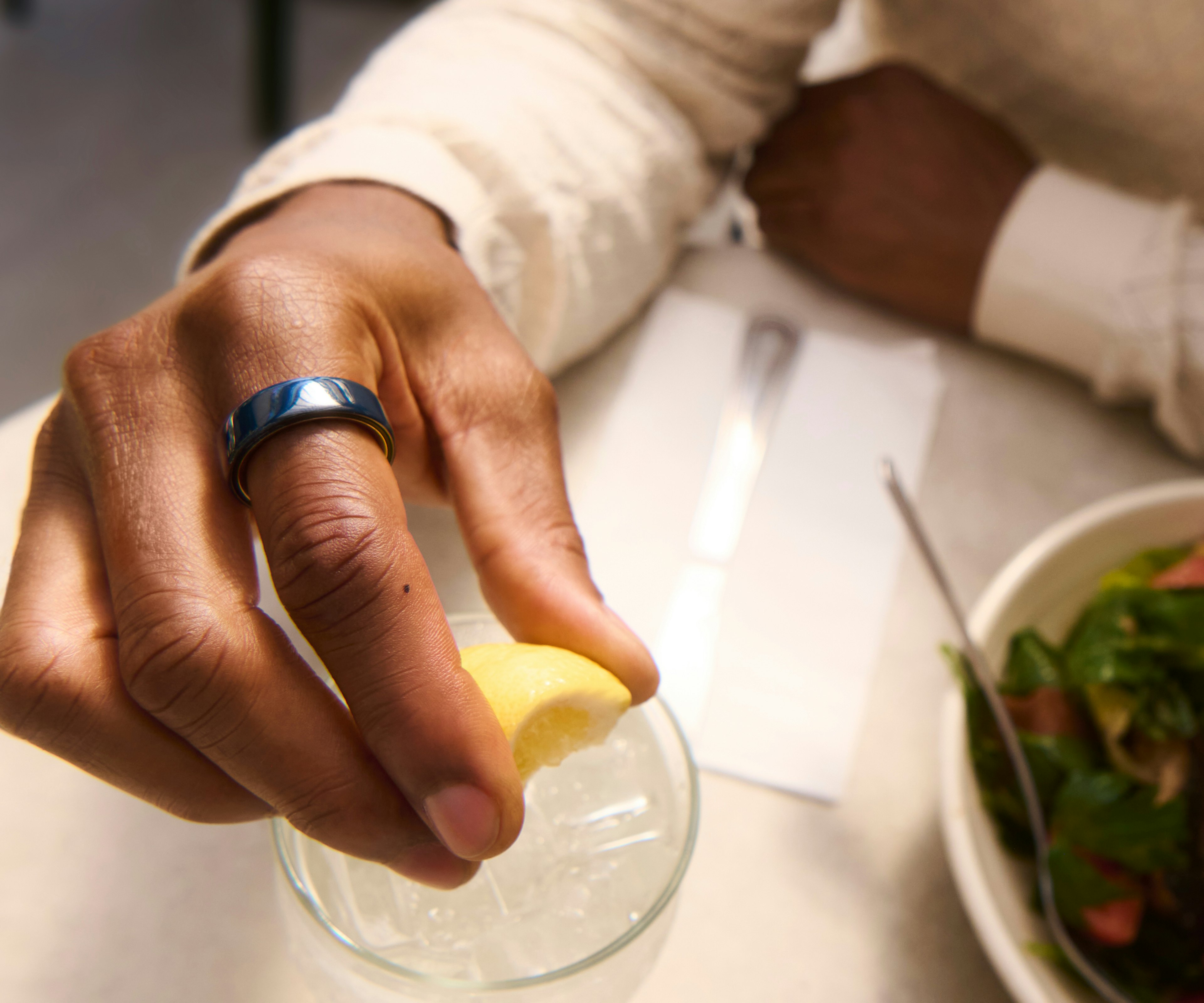 一個人手指上戴著 Midnight 色 Oura Ring 4 Ceramic 的手部特寫