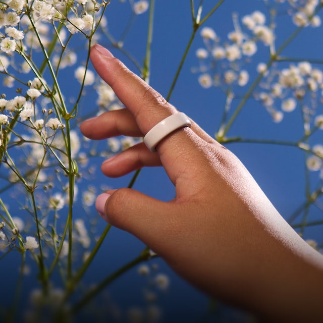 一個人手指上戴著 Cloud Oura Ring 4 Ceramic 的手部特寫