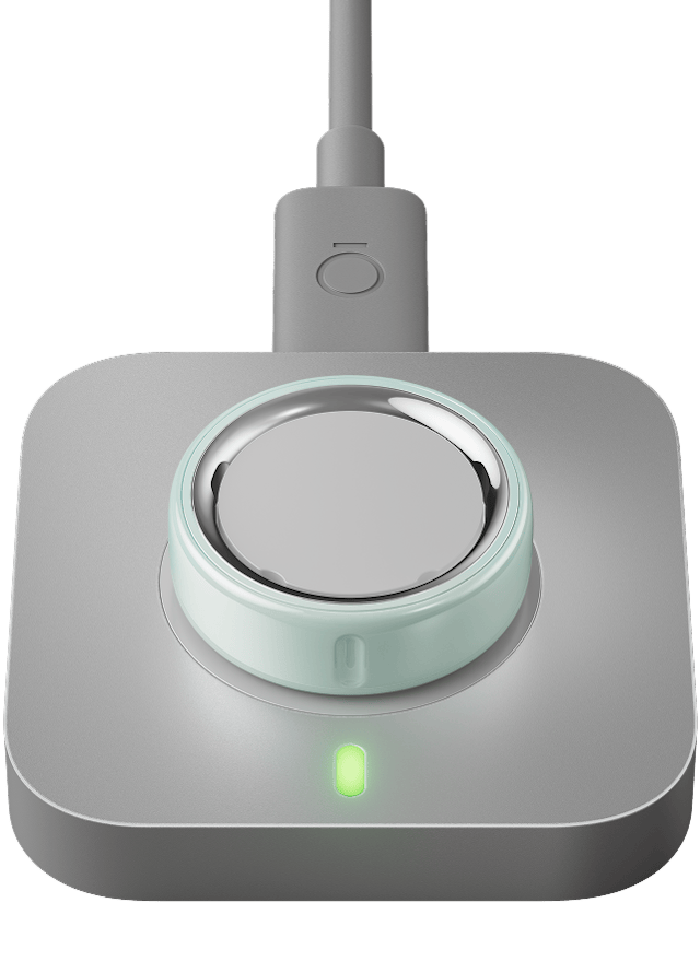 充電器上放著一枚 Tide 色 Oura Ring 4 Ceramic